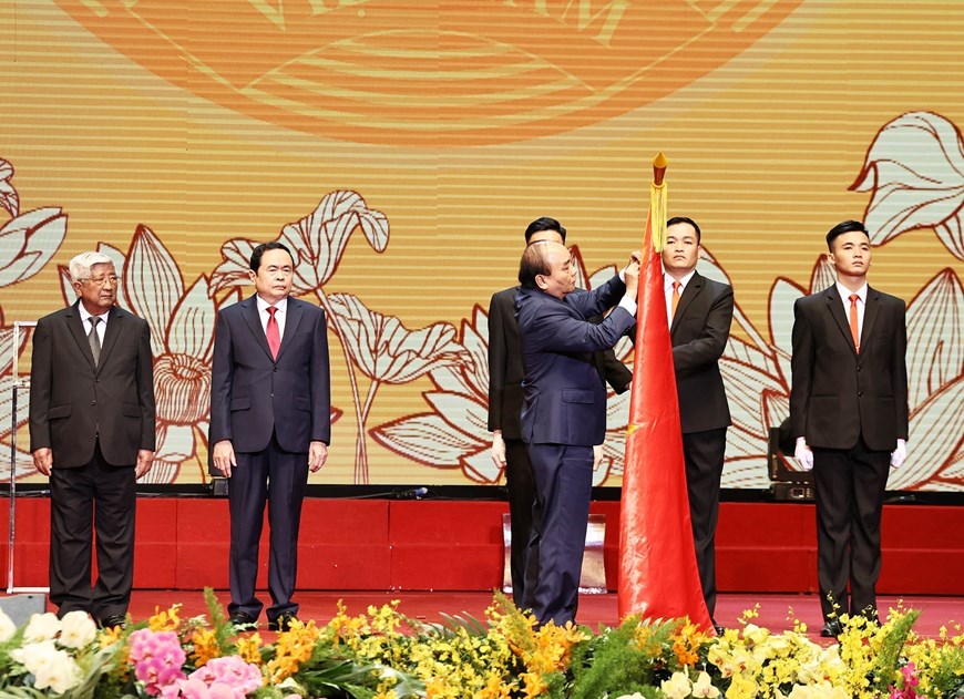 Prime Minister Nguyen Xuan Phuc, Chairman of the Central Council for Emulation and Commendation pins the Ho Chi Minh Order to the Vietnam Fatherland Front’s traditional flag