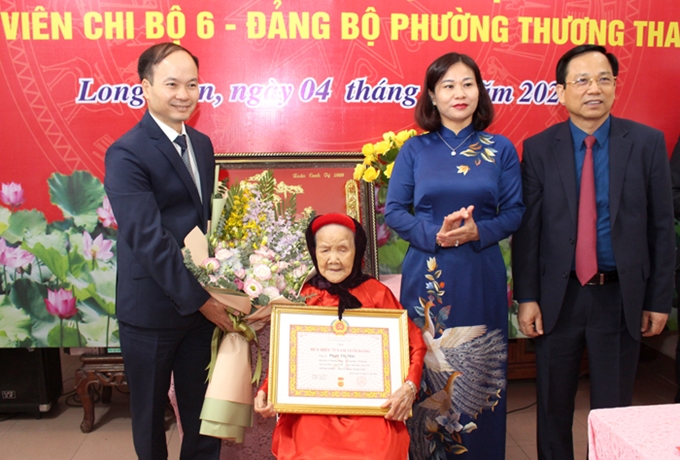 Presenting the 75-year Party badge to Pham Thi Mut (Source: hanoimoi.com.vn)