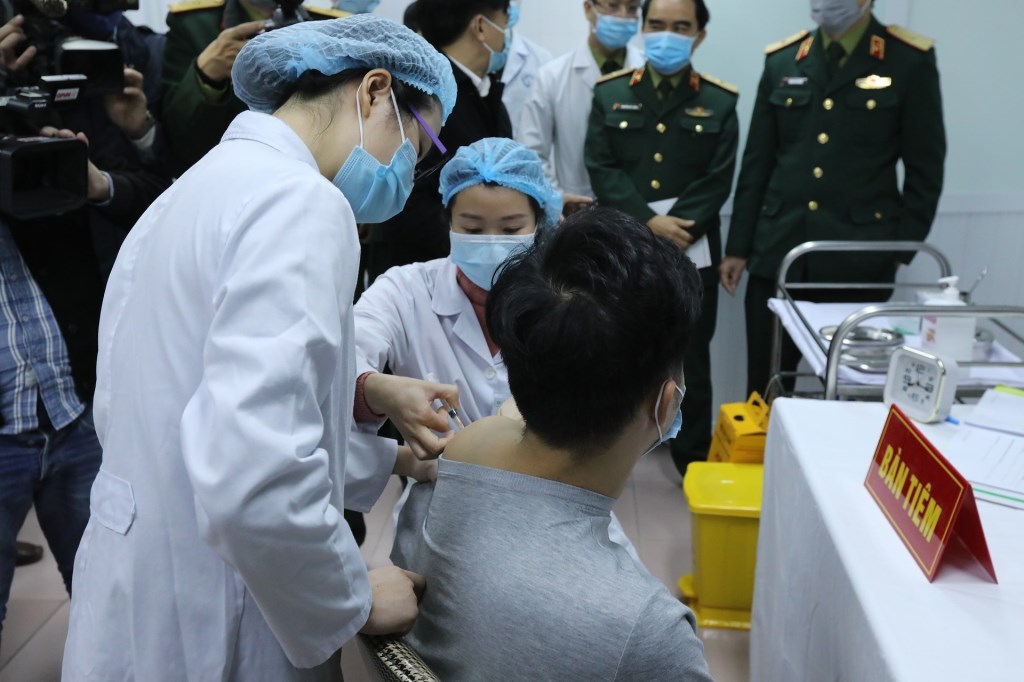 The first shot of vaccine Nanocovax, Vietnam's first Covid-19 vaccine, is given to a male volunteer. (Photo: VNA)