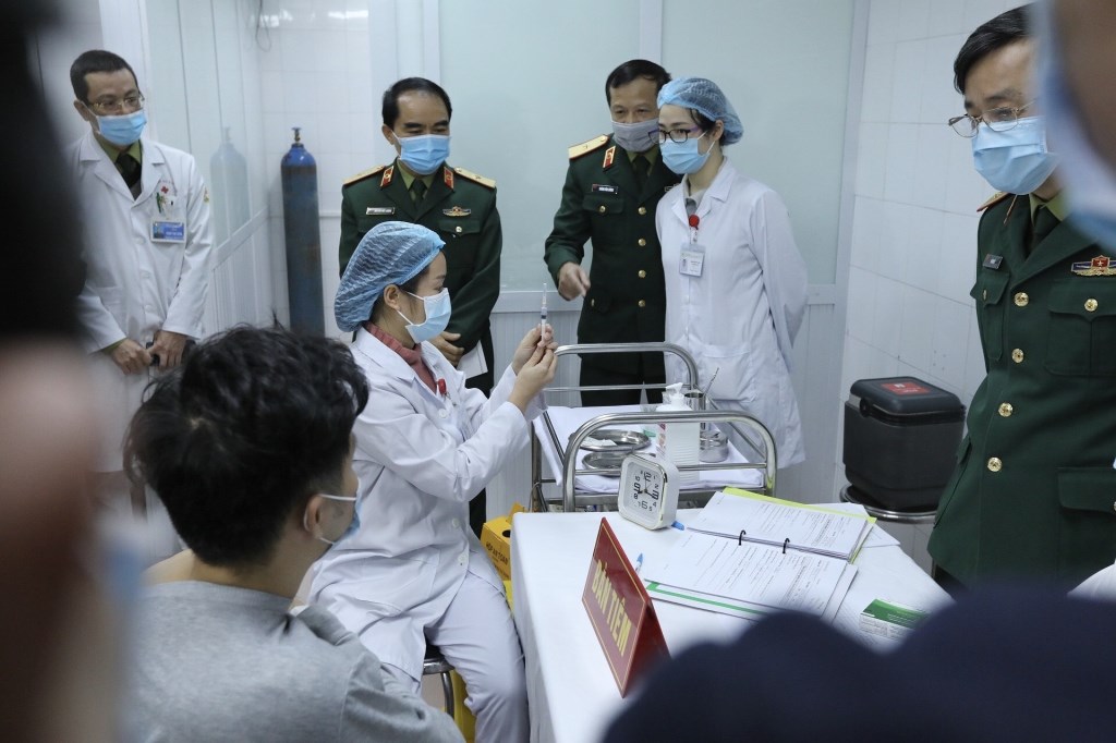 Director of the Military Medical Academy Do Quyet chairs a meeting before starting the first injection of COVID-19 vaccine Nanocovax on three volunteers. (Photo: VNA)