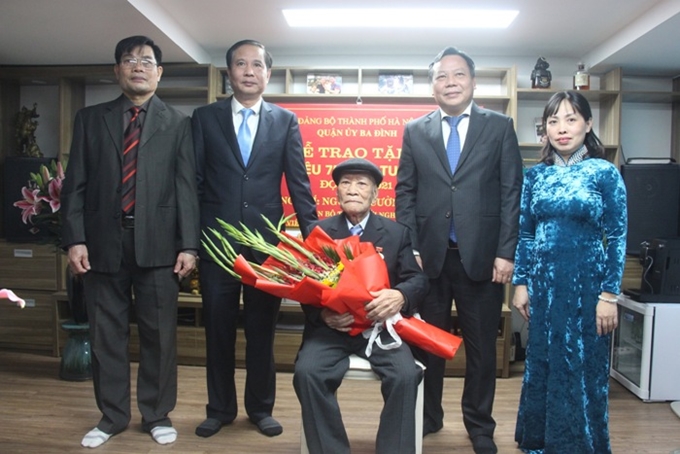 Deputy Secretary of Hanoi City Party Committee Nguyen Van Phong presented a 75-year Party badge and presented flowers to party member Nguyen Cuong Khang  (Source: CPV)