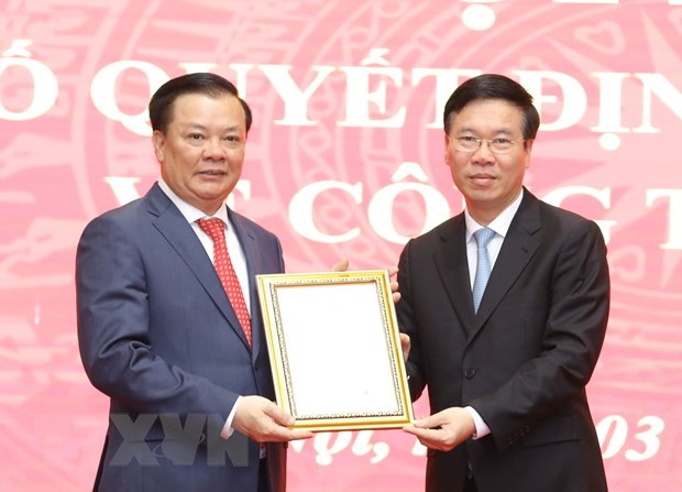 Permanent Member of the Party Central Committee’s Secretariat Vo Van Thuong (R) hands over the Politburo's decision to new Secretary of the Party Committee of Hanoi Dinh Tien Dung (Photo: VNA)