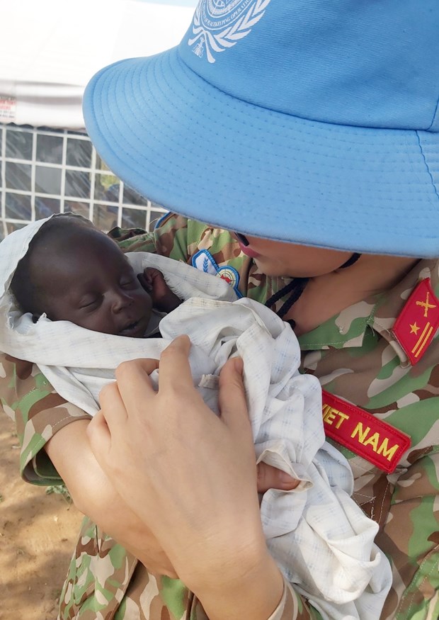 Lieutenant Colonel Nguyen Thi Minh Phuong holds a South Sudanese baby during her first day-long patrol as a military observer, in December 2019. (Photo by courtesy of Lieutenant Colonel Nguyen Thi Minh Phuong)
